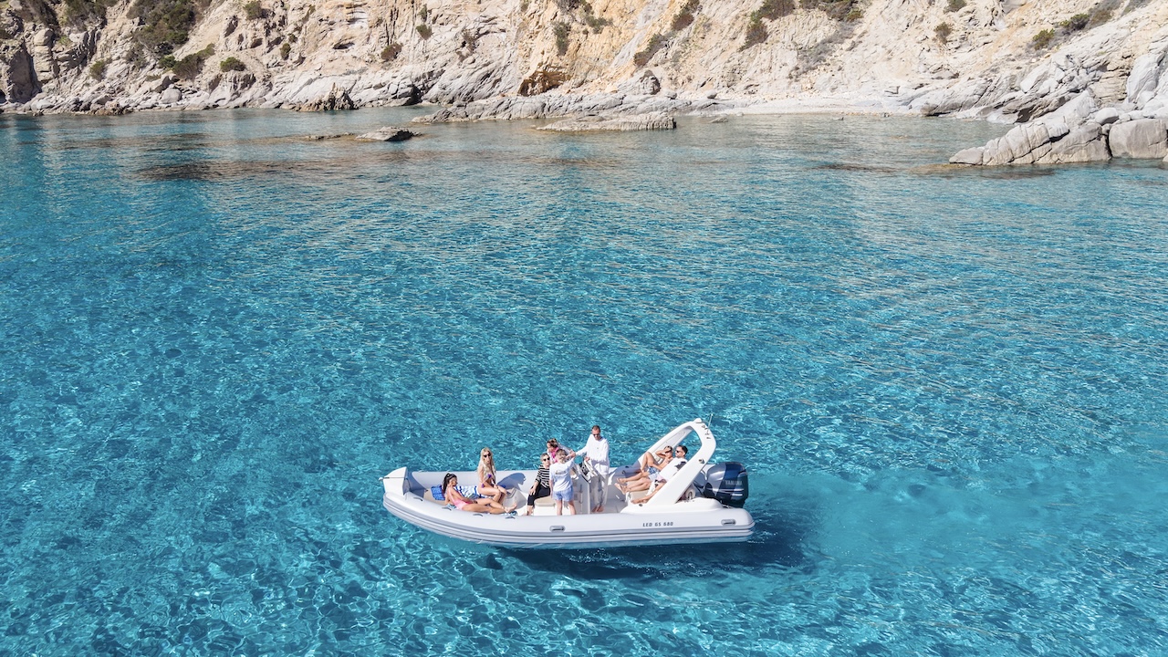 Un gruppo di persone gode di un tour in gommone con snorkeling e aperitivo