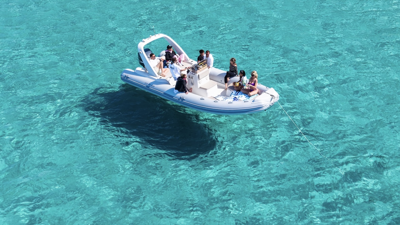 Un gruppo di persone su una barca gommone in acqua blu