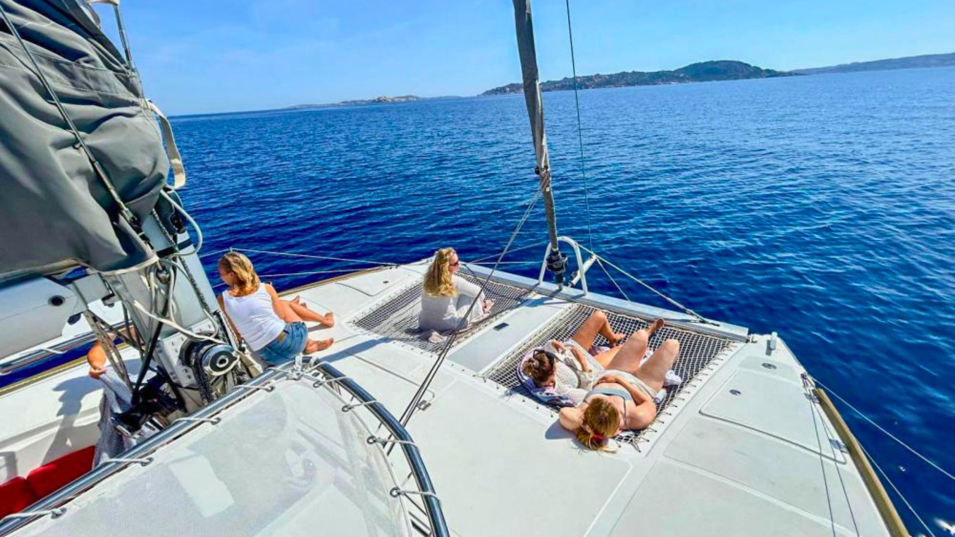 Photo d'un catamaran avec des personnes assises et couchées à bord