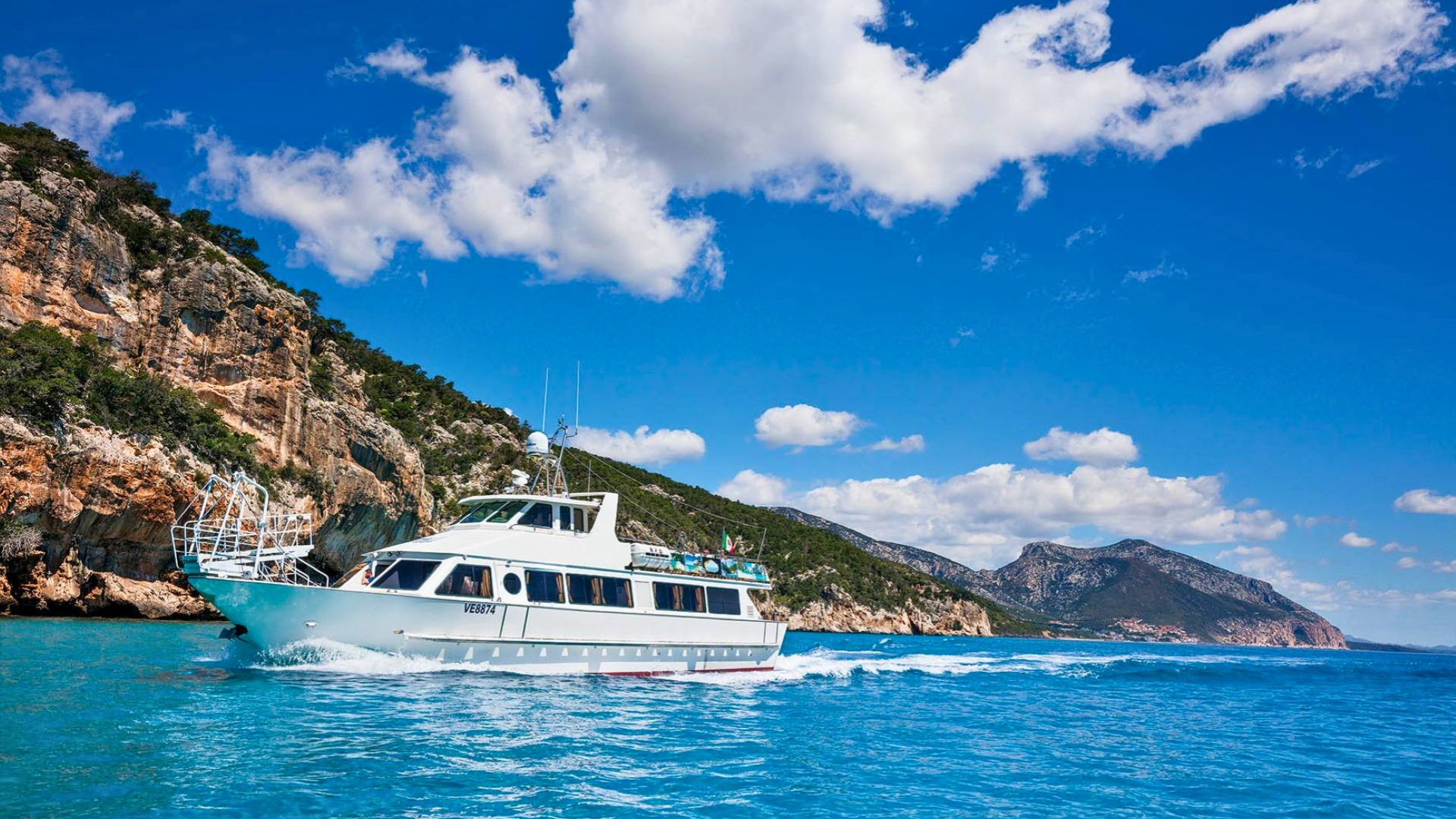 Ein Motorschiff segelt entlang der Küste des Golfs von Orosei