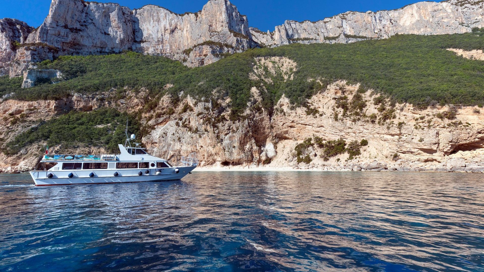 Ein Motorschiff segelt entlang einer außergewöhnlich schönen Küste