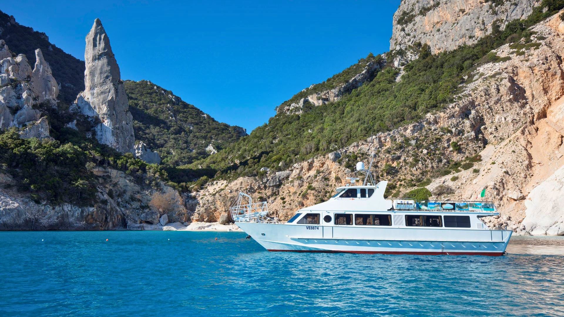 Ein Motorschiff segelt entlang einer außergewöhnlich schönen Küste