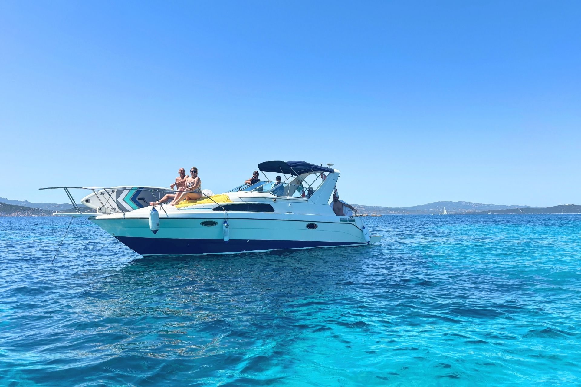 Image of a group of people on a speedboat in the archipelago of La Maddalena, Sardinia, with crystal clear waters and breathtaking views.