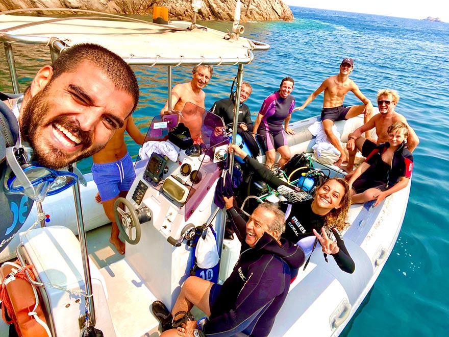 A group of people in diving suits on a boat, ready for a dive in the archipelago of La Maddalena