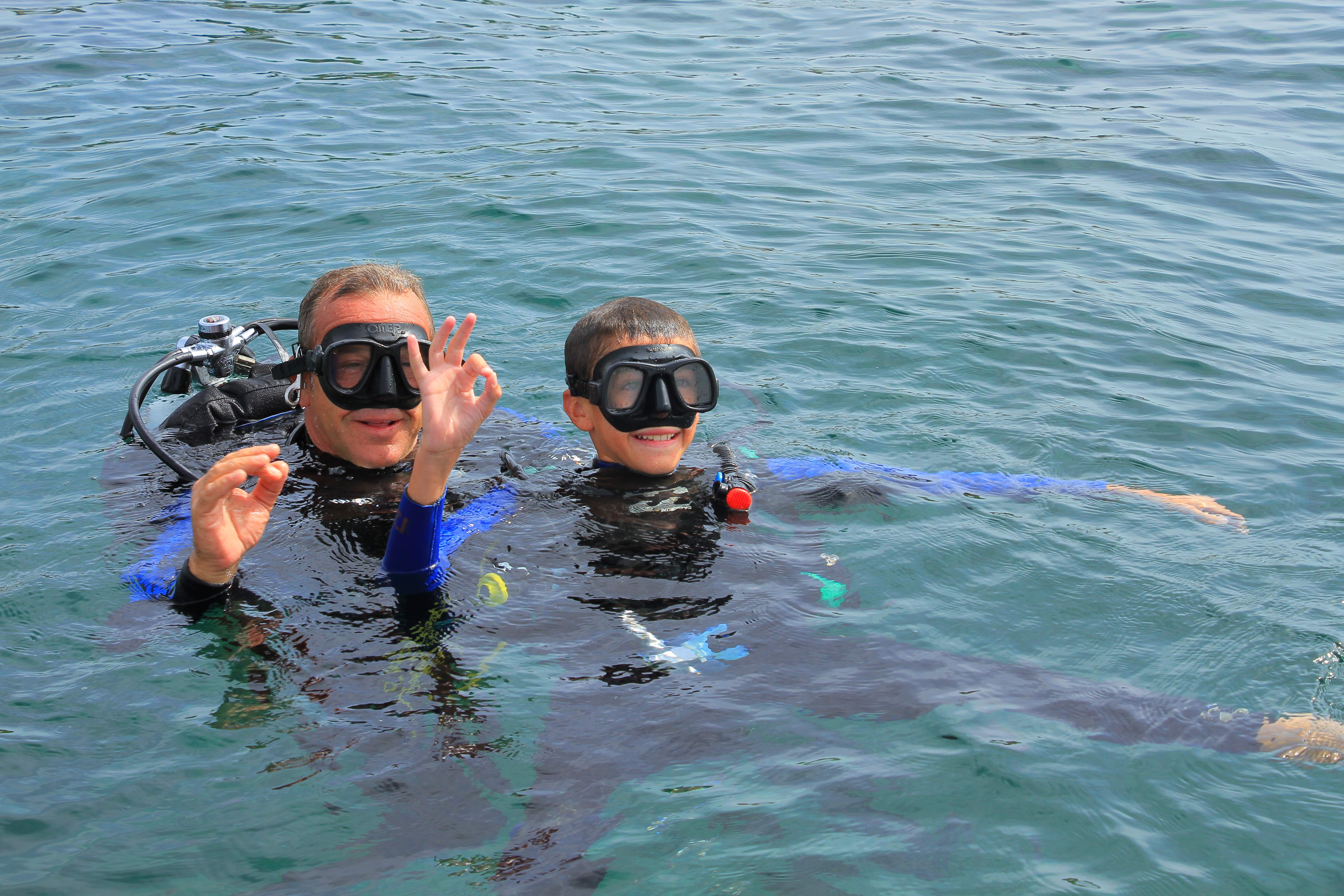 people in diving suits on a boat, ready for a dive in the archipelago of La Maddalena