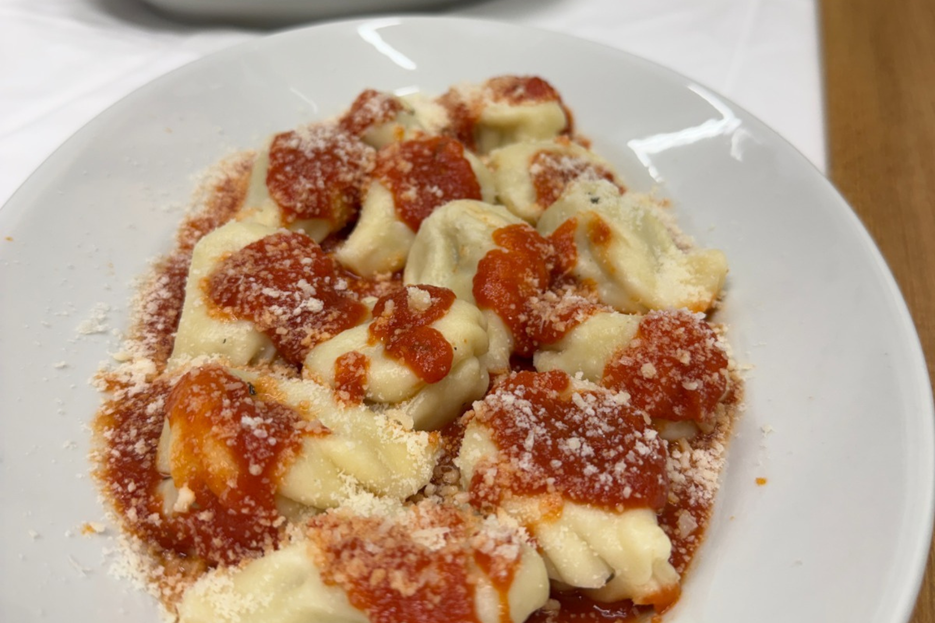 Une assiette de raviolis Tortoliesi frais ou de culurgiones, avec sauce et vin local
