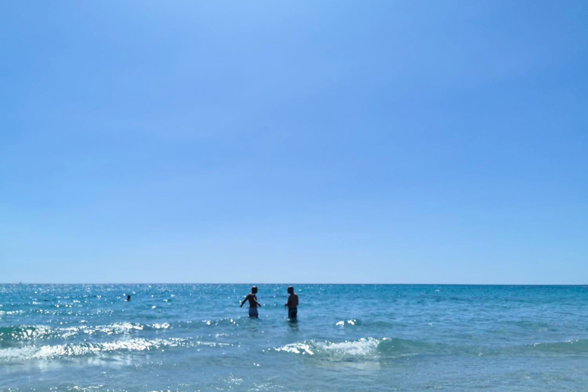 Zwei Personen genießen an einem sonnigen Tag kristallklares Meerwasser