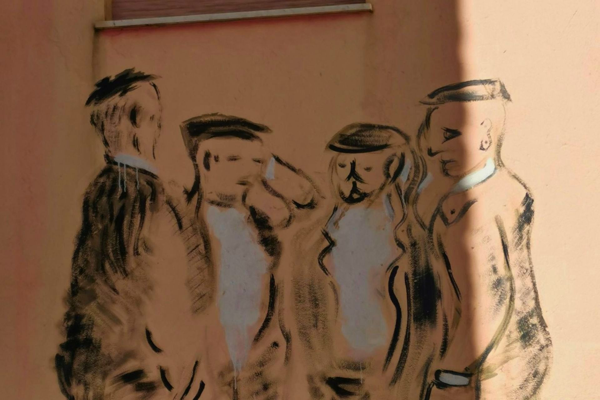 Graffiti de cuatro hombres con sombreros cantando a Tenores