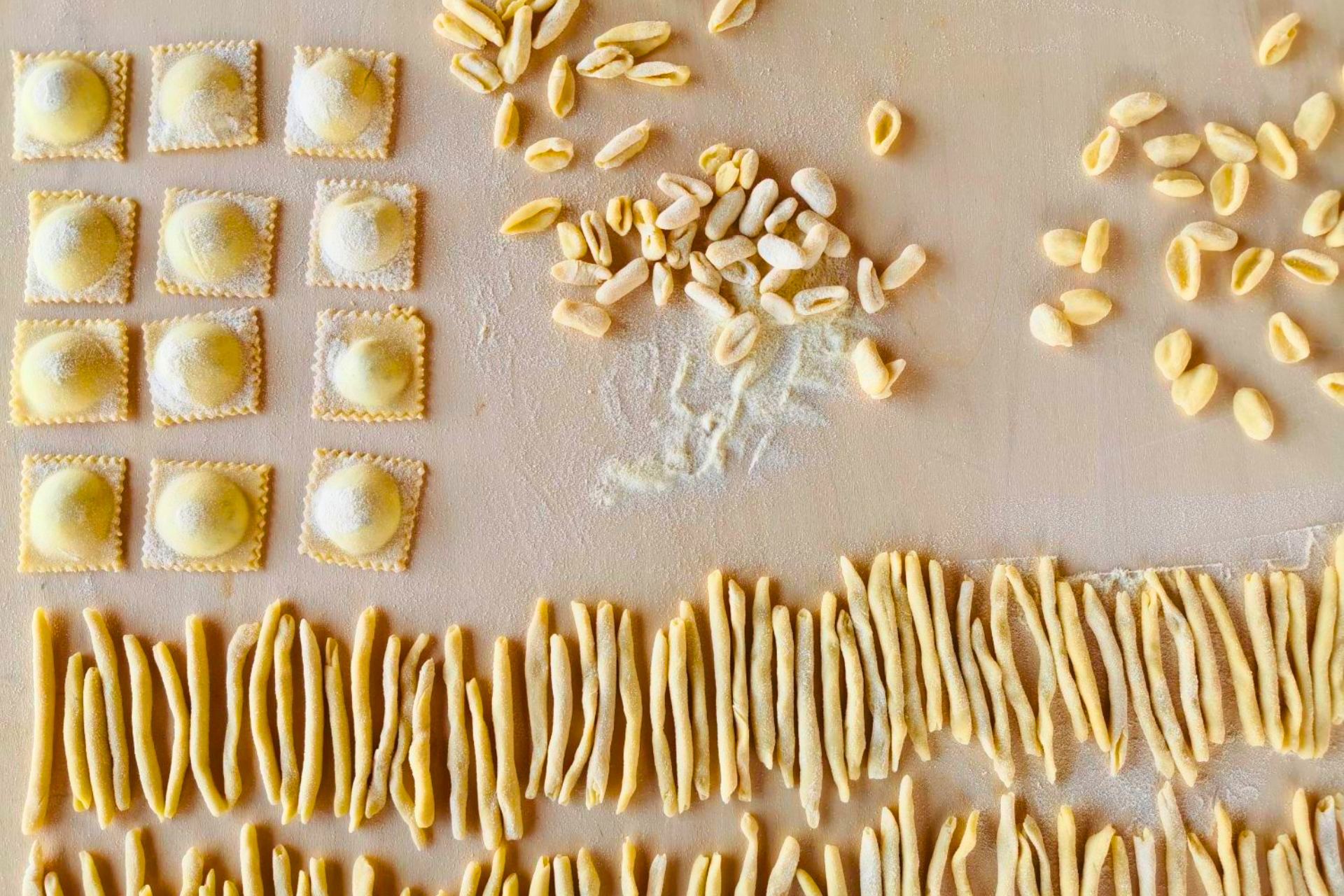 Imagen de pasta fresca dispuesta sobre una mesa, con ravioles y fettuccine
