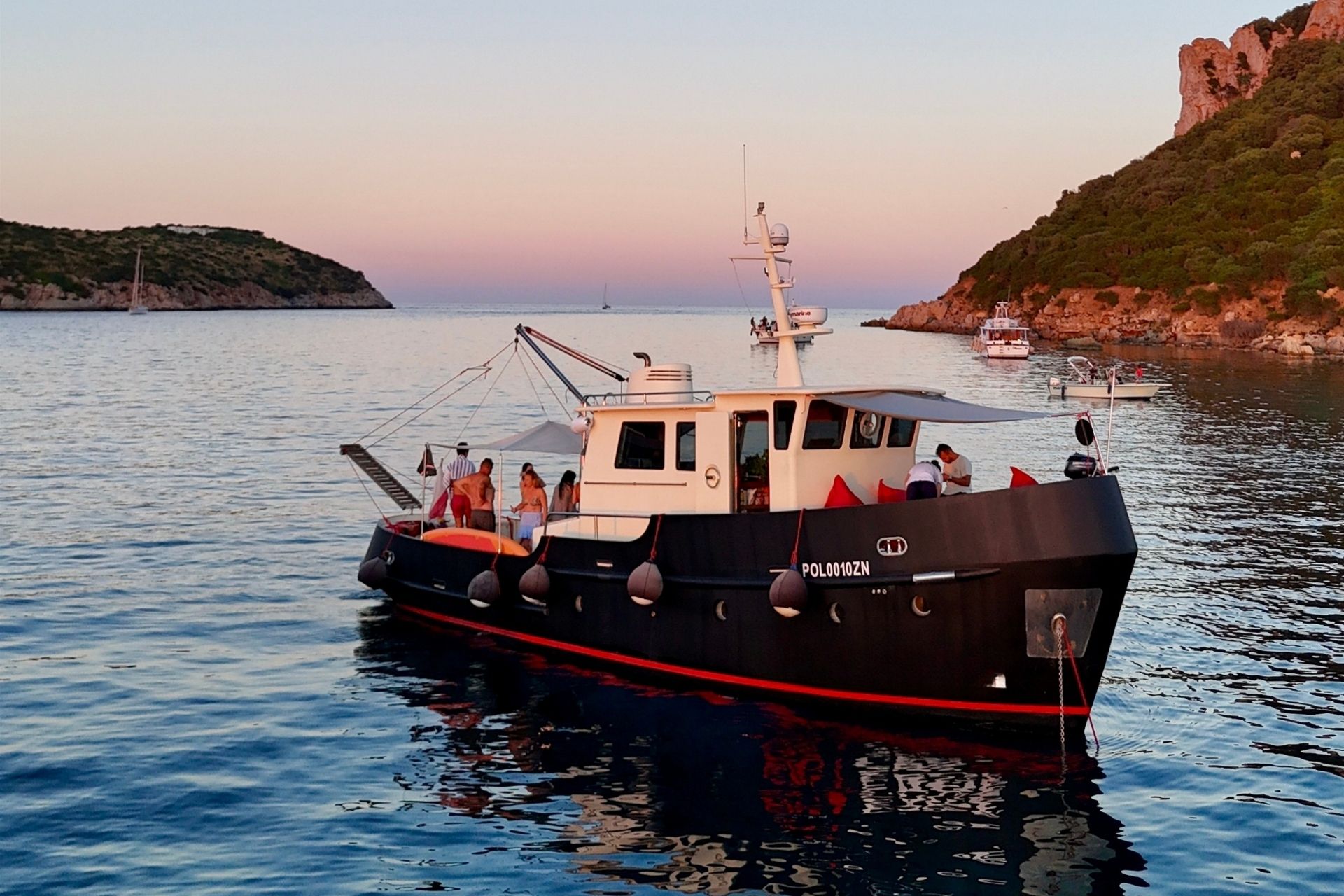 Bateau vintage avec des personnes à bord et des criques cachées en arrière-plan
