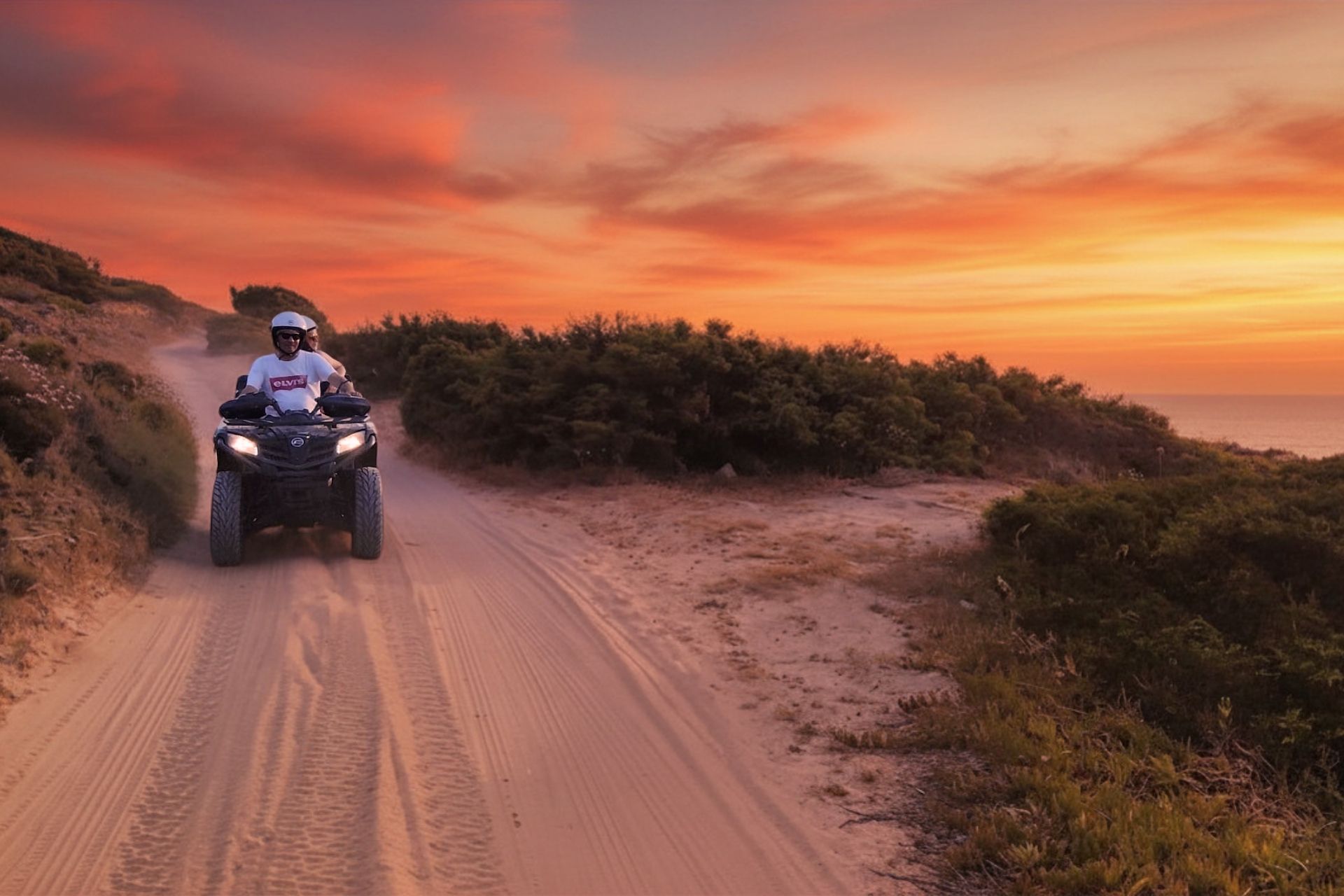 Deux personnes en quad sur un chemin de terre au coucher du soleil