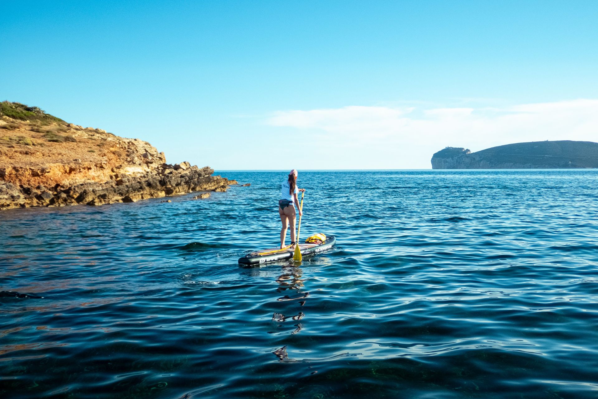 Une personne debout sur une planche de SUP en mer