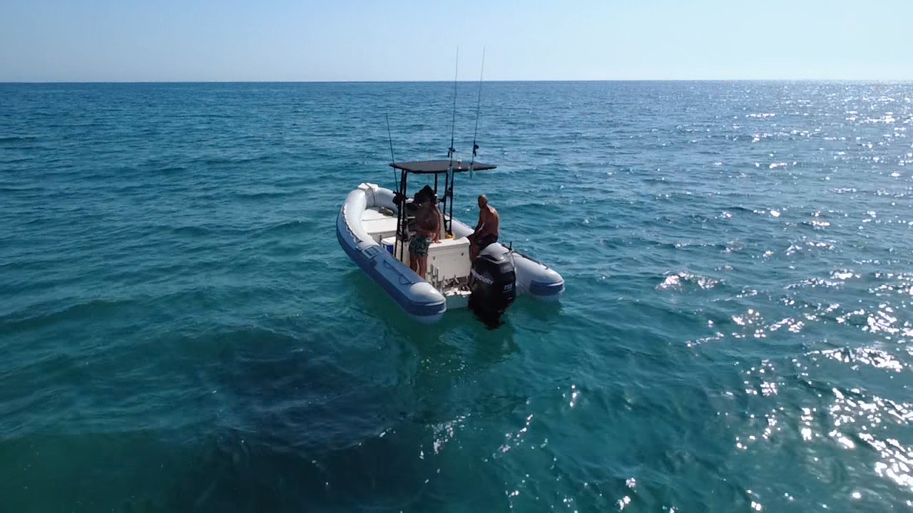 Image of a dinghy with fishermen at sea, active in an attempt to catch typical Mediterranean fish.