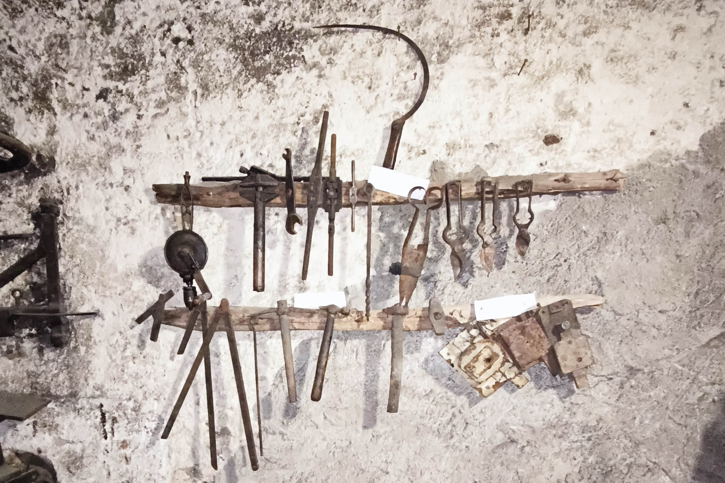 Herramientas de artesanía colgadas en la pared en un entorno rústico