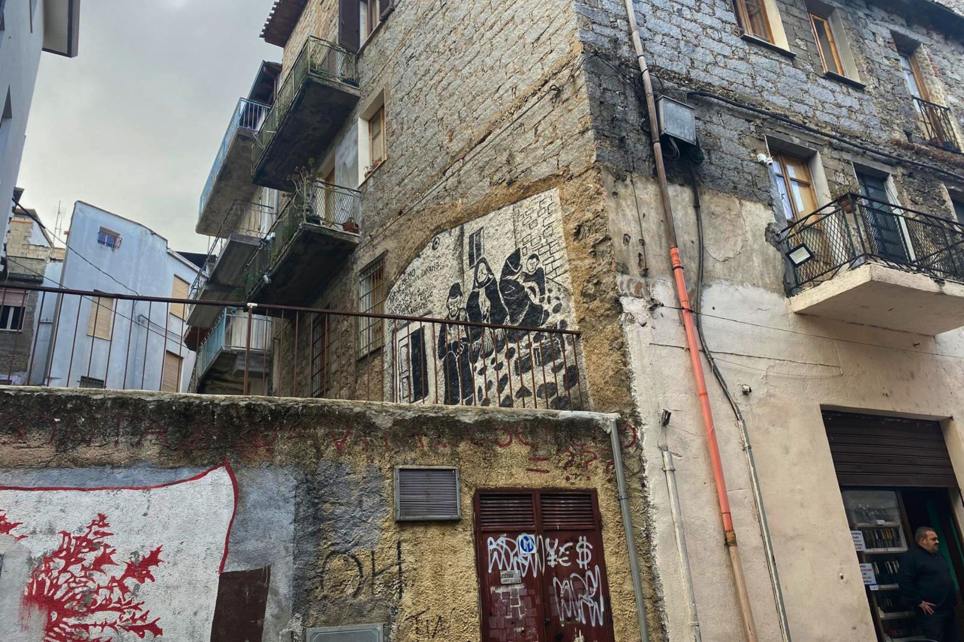 Bâtiment urbain avec façade ancienne et peintures murales représentant des personnages en costume traditionnel