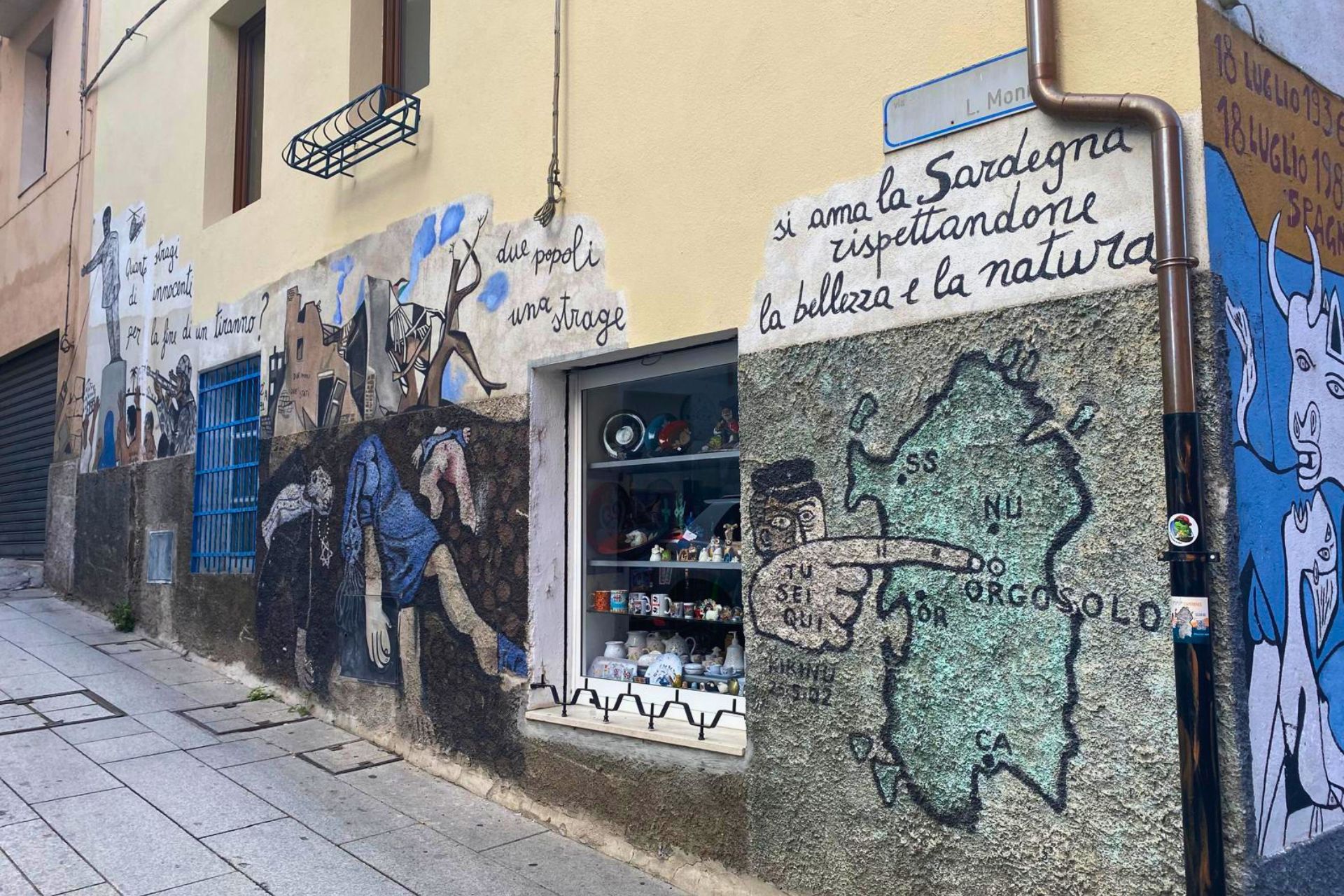 Une peinture murale sur un bâtiment qui représente un berger et un ancien carnaval barbare, ainsi que d'autres peintures murales