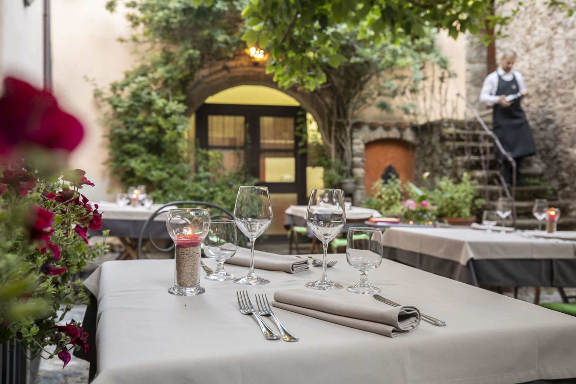 Mesas colocadas al aire libre en un restaurante con vistas a un pueblo sardo