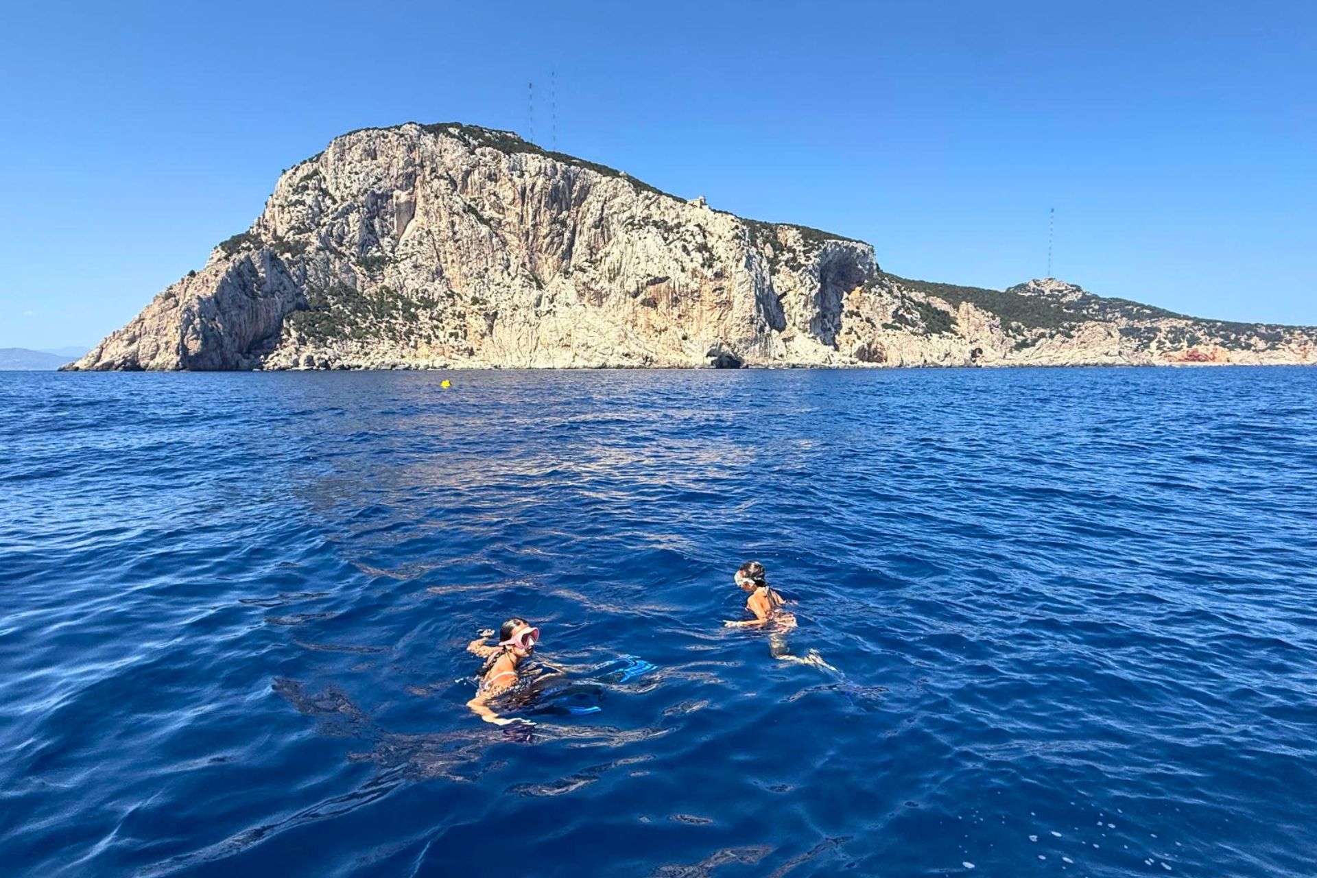 Due persone fanno snorkeling in mare aperto, circondate da una natura incontaminata e paesaggi mozzafiato
