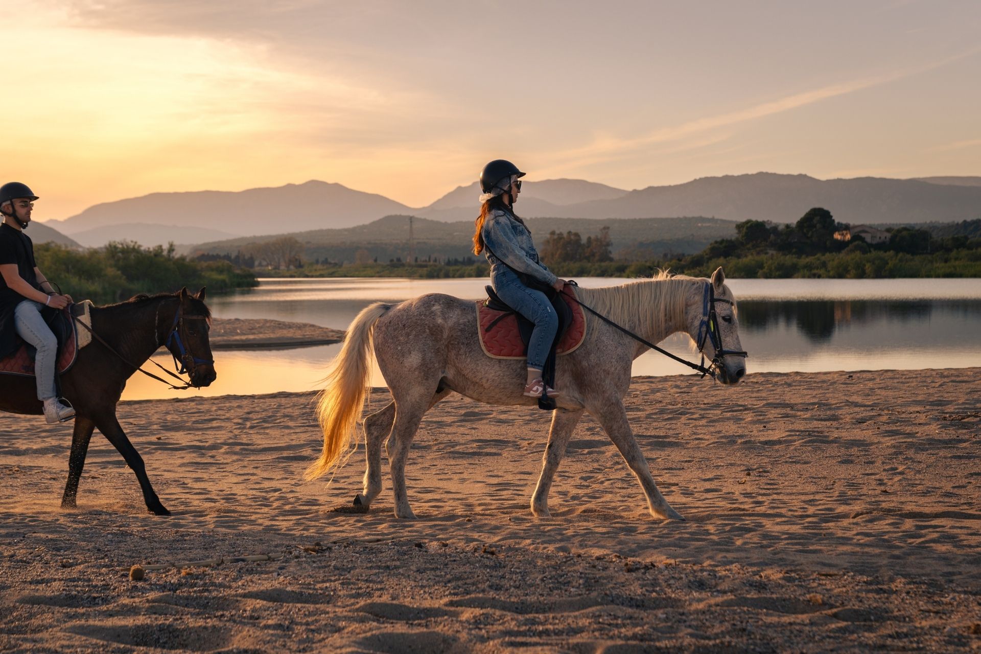 Horseback ride on the beach of Orosei at sunset, at the mouth of the Cedrino river.