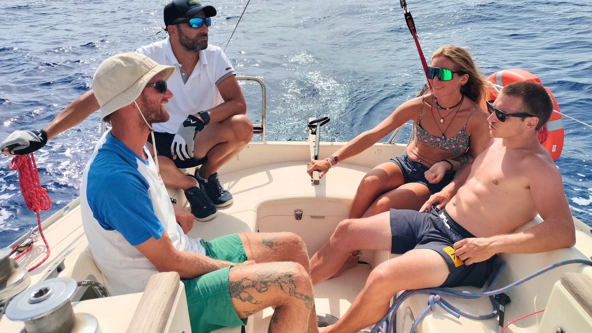 Groupe de personnes à bord d'un voilier naviguant le long de la côte est de la Sardaigne, près d'Arbatax, avec des arrêts pour nager et se détendre à bord