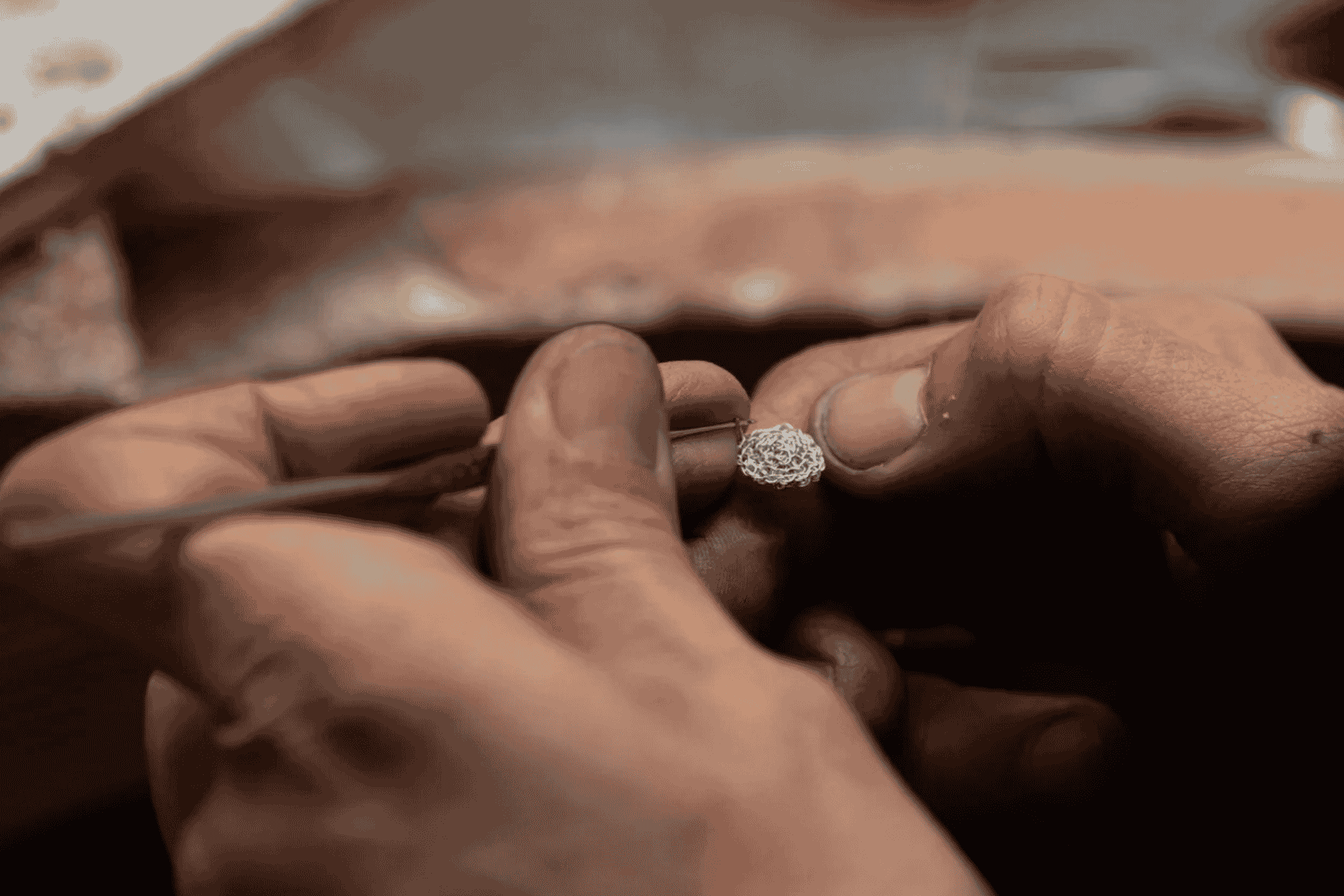 Persona que crea una joya con hilo de plata en un taller de orfebrería de Cagliari