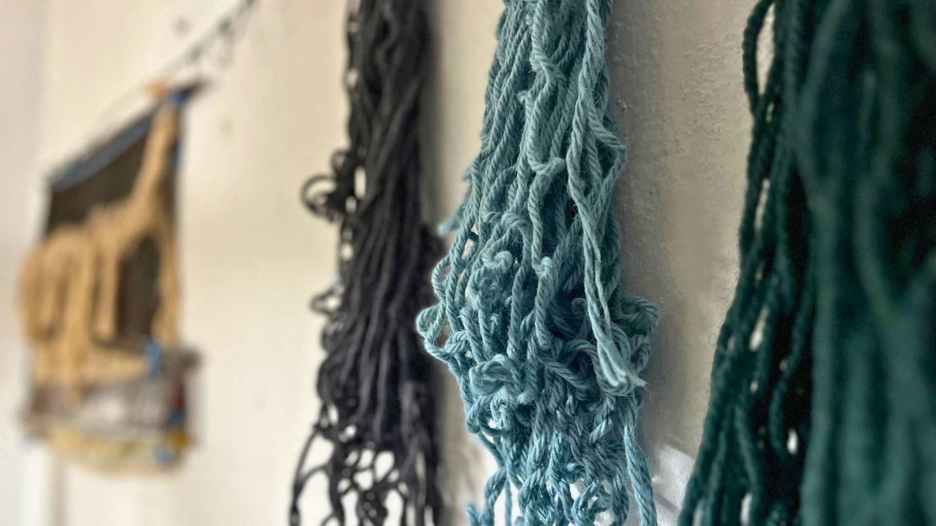 Tre fili di lana di diverso colore, nero, verde e azzurro