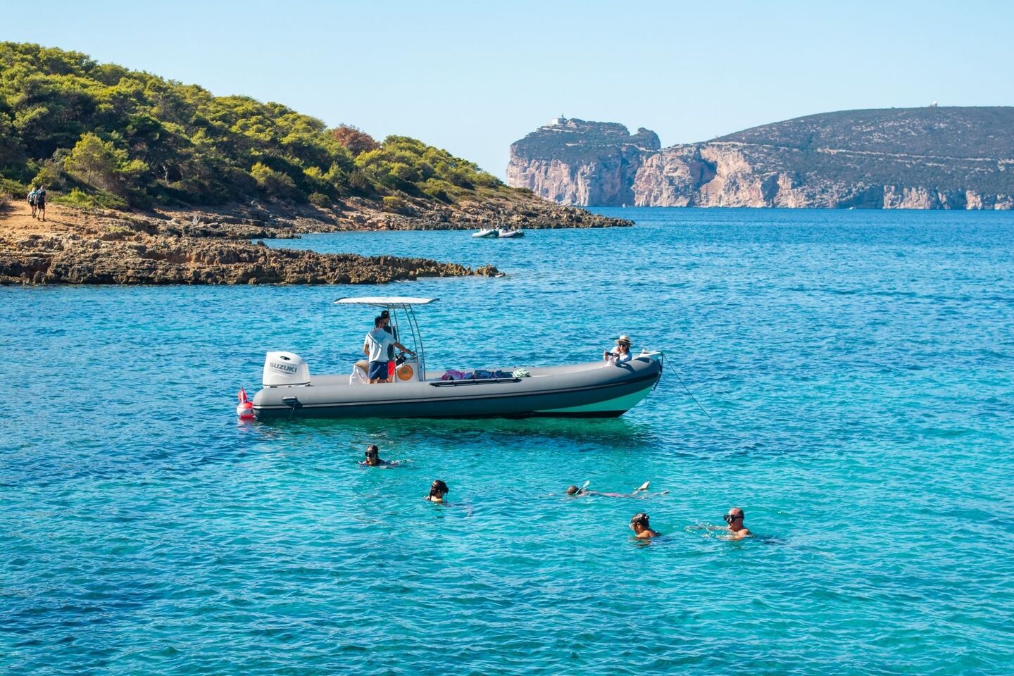 Dinghy stops near the coast of the Porto Conte Park