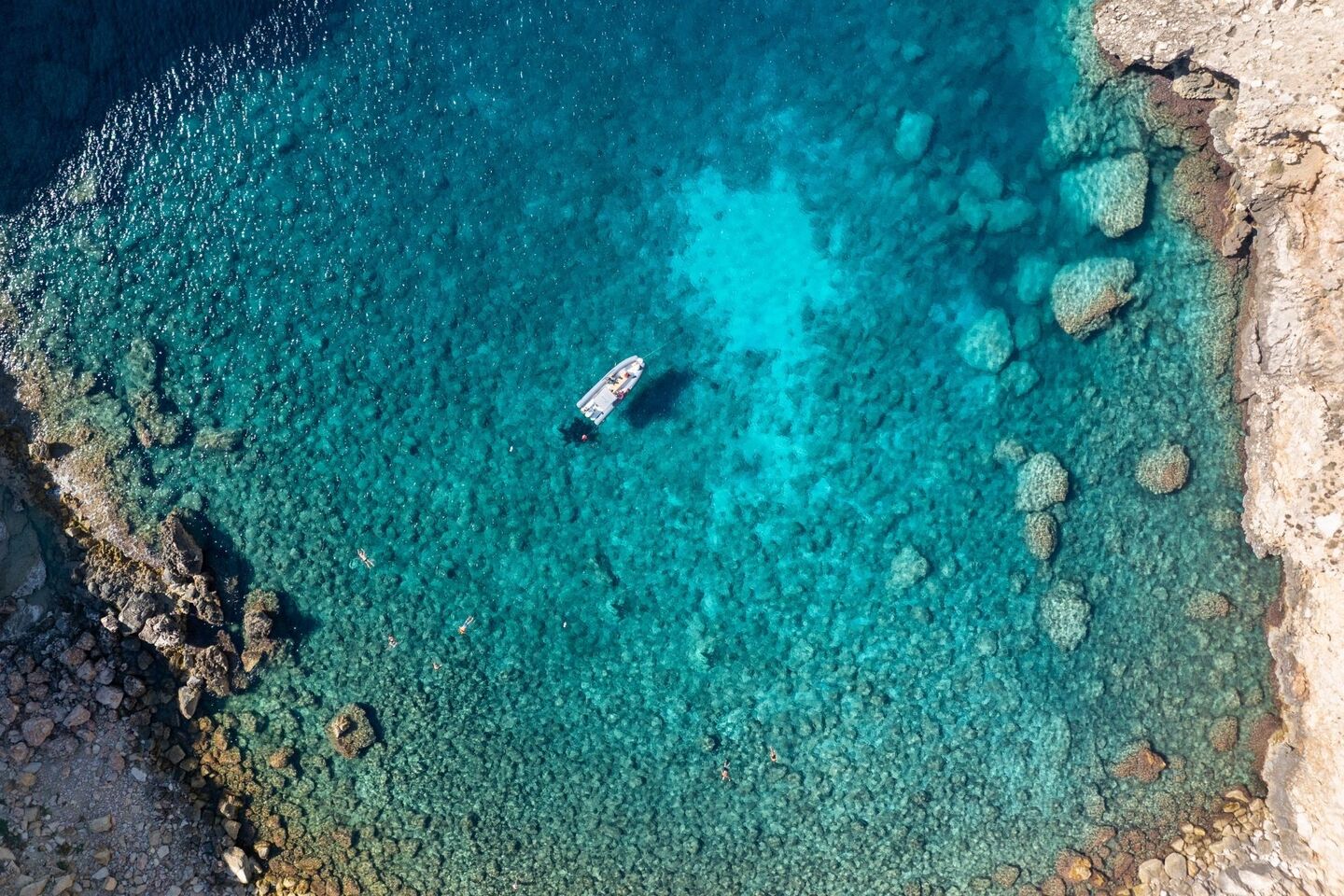 The dinghy stops in the clearer waters of the Porto Conte park in Capo Caccia
